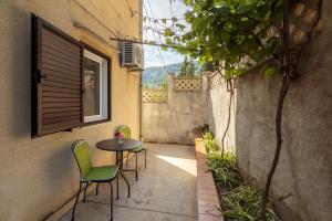 un pequeño patio con 2 sillas y una mesa en Apartmani Jordana, en Komiža