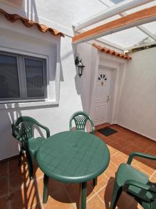 特赫達的住宿－Casa rural Juan y Juana Canino，配有电视的客房内的绿色桌椅
