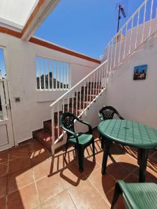 a patio with two chairs and a table and a staircase at Casa rural Juan y Juana Canino in Tejeda