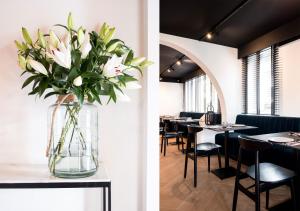 eine Vase Blumen auf einem Tisch in einem Restaurant in der Unterkunft ENSO - Boutique Hotel in Knokke-Heist