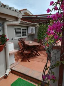 un patio con mesa, sillas y flores en B&B Le Terrazze, en Crotone