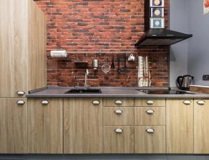 a kitchen with a brick wall and a sink at Loft in Arcadia in Odesa