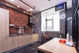 a kitchen with a wooden table and a brick wall at Loft in Arcadia in Odesa