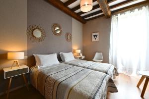 ein Schlafzimmer mit einem großen Bett und einem Fenster in der Unterkunft Maison Canterou in Monein