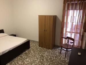 sypialnia z łóżkiem, krzesłem i szafką w obiekcie Monopoli Puglia Salento casa esclusiva 12 posti w mieście Monopoli