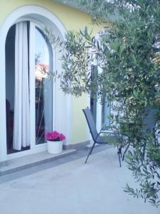 a chair on a balcony with a window at Ana Rooms in Krk