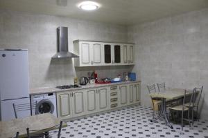 アドレルにあるГостевой дом на изумруднойのキッチン(白いキャビネット、テーブル、冷蔵庫付)