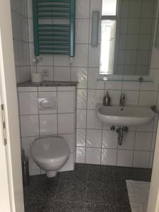 a white bathroom with a toilet and a sink at Gästeapartment Kübel in Uedem