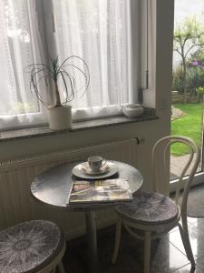 een tafel en twee stoelen met een koffiekopje erop bij Gästeapartment Kübel in Uedem