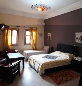 1 dormitorio con 2 camas, mesa y silla en Ecolodge Espace Tamount en Demnat