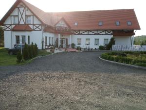 a large white house with a red roof at B&B Źródlana 46 in Olszyna