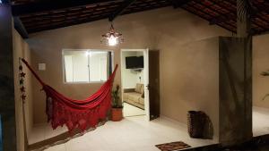 una sala de estar con una hamaca roja en la pared en Pousada das Bromélias en Porto De Galinhas