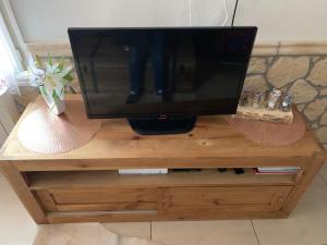 a television sitting on top of a wooden stand at ANNECY Sainte Claire vieille ville 38m2 Terrasse proche gare et lac 4 pers 3 étoiles in Annecy