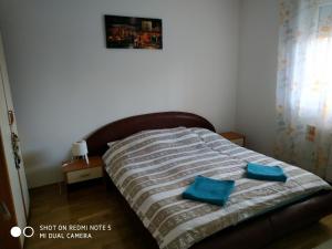 - un lit avec 2 oreillers bleus au-dessus dans l'établissement Apartment Jelena, à Zrenjanin