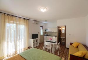 Una sala de estar con un sofá y una mesa y una cocina. en Apartmani Jordana, en Komiža