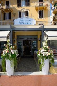 a building with two large white vases filled with flowers at Hotel Ristorante Milton in Varazze