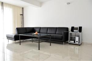 un soggiorno con divano nero e tavolo di Apartment Rab Hills a Rab