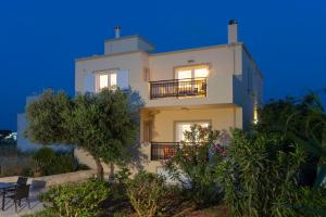 una casa blanca con balcón por la noche en Casa Di Mario, en Kokkíni Khánion