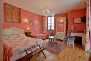 a bedroom with red walls and a bed and a fireplace at Dolwin in Argelès-Gazost