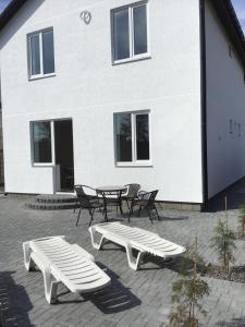 a group of tables and benches in front of a building at Адмирал 3. Вилла in Koblevo