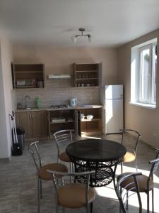 a kitchen with a table and chairs and a refrigerator at Адмирал 3. Вилла in Koblevo