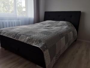 a bed in a bedroom with a blanket on it at Central Sun in Daugavpils