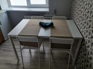 a dining room table with two chairs and a blue bag on it at Central Sun in Daugavpils