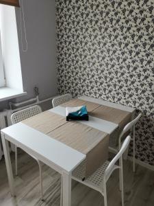 a white table and chairs in a room with wallpaper at Central Sun in Daugavpils