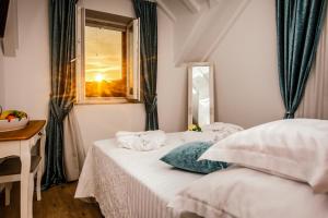 a bedroom with a bed and a window and a mirror at Heritage Hotel Dea Hvar in Hvar