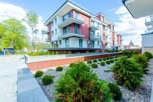 an apartment building with a garden in front of it at Apartament K&K Klifowa Rewal in Rewal