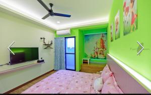 a bedroom with green and pink walls and a tv at 澎湖寶貝民宿 in Huxi