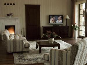 a living room with two couches and a tv at Villa Victoria in Rydzewo