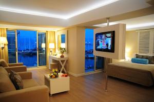 a living room with a couch and a flat screen tv at Alesta Yacht Hotel in Fethiye