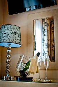 a table with a lamp and two wine glasses at Hotel Condes de Castilla in Segovia