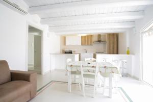 a white kitchen and living room with a table and chairs at B&B Monsignore in Vieste