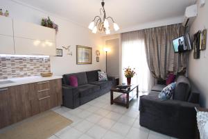 ein Wohnzimmer mit 2 Sofas und einer Küche in der Unterkunft Luxury flat in Platamonas 2' from the beach! Great VFM!!! in Platamonas
