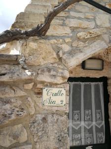 una pared de piedra con un cartel en un edificio en Masseria Sciaiani Piccola, en Villa Castelli