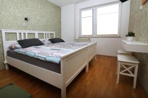 a bedroom with a white bed with a window at Apartma Dolinar in Gorenja Vas