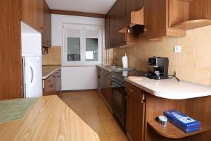 a kitchen with wooden cabinets and a white refrigerator at Apartma Dolinar in Gorenja Vas +9 photos