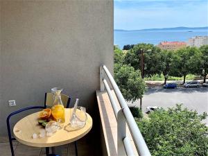 einen Tisch mit Gläsern Orangensaft auf dem Balkon in der Unterkunft Sea Star in Split