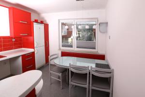 cocina con armarios rojos y mesa de cristal en Apartma Dolinar en Gorenja Vas
