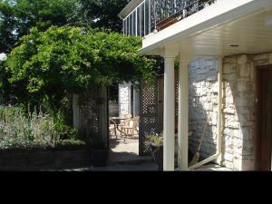 a porch of a house with a table and a balcony at Grey Rose Suites in Hanover