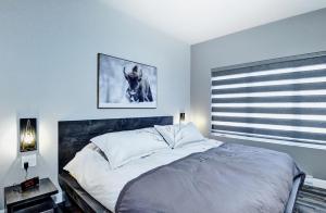 Un dormitorio con una cama con un cuadro en la pared. en Chalet 06 Chemin Blanc by Les Chalets Alpins, en Stoneham