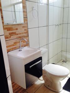 y baño con lavabo y aseo. en Pousada Manacá, en São José do Rio Pardo