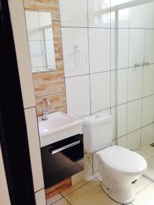 uma casa de banho com um WC, um lavatório e um chuveiro em Pousada Manacá em São José do Rio Pardo