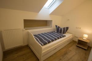 1 dormitorio con cama con sábanas azules y ventana en Fewo Ben, en Lohme