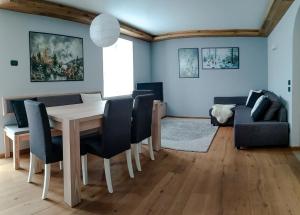 salon ze stołem, krzesłami i kanapą w obiekcie Casa Zone w mieście Tesero +2 zdjęcia
