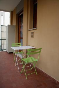 een tafel en twee groene stoelen naast een muur bij INTERNO 12 in Varazze