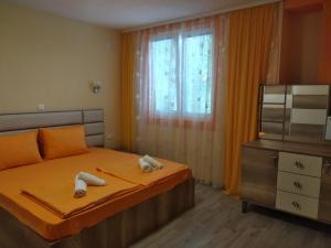 een slaapkamer met een bed, een dressoir en een televisie bij Villa Mimi in Peštani