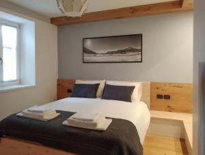 um quarto com uma cama com duas toalhas em Casa Zone em Tesero